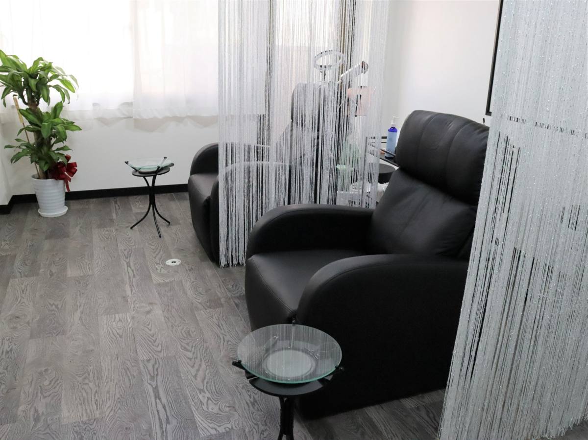 黒いリクライニングチェアが並ぶ施術スペース